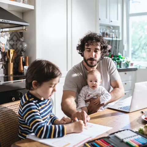 Picture of Dad working from home while also looking after children