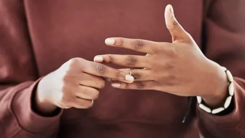 Picture of someone's hands as they hold their wedding or engagement ring.